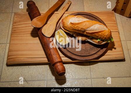 Milanesa argentinisches Steak-Sandwich mit Salat, Tomaten, Käse, Ei, Zitrone, Würstchen, Pommes. LKW-Lebensmittel. Fast Food. Selektiver Fokus. Stockfoto