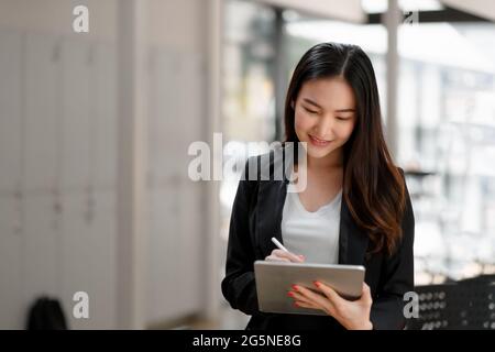 Porträt einer asiatischen Geschäftsfrau mit digitalem Tablet im Besprechungsraum des Unternehmens Stockfoto