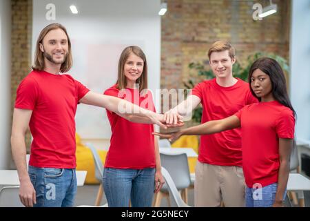 Gruppe junger Menschen in roten T-Shirts im Innenbereich Stockfoto