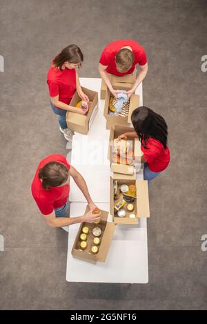 Draufsicht auf junge Freiwillige, die Charity-Boxen packen Stockfoto