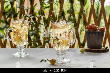 Zwei Gläser mit hausgemachtem Stachelbeeren-Eistee oder Limonade mit Thymus. Stockfoto