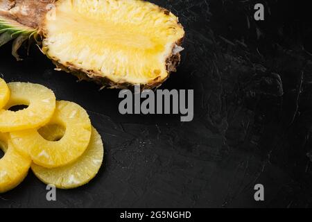 Ananas-Cut-Set, auf schwarzem dunklen Stein-Tischhintergrund, mit Platz für Text Stockfoto