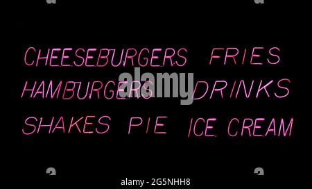 Hamburger-Diner-Menü im Pink Neon-Restaurant im Regenfenster Stockfoto