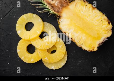 Ananas Cut Set, auf schwarzem dunklen Steinteller Hintergrund, Draufsicht flach liegend Stockfoto