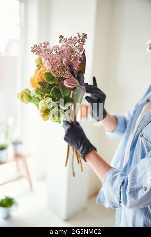 Professionelle weibliche Floristin, die einen Frühlingsstrauß kreiert Stockfoto