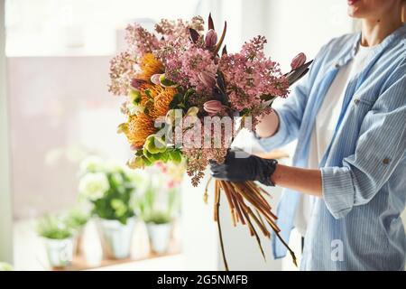 Frau, die ein exquisites Blumenarrangement im Frühling macht Stockfoto