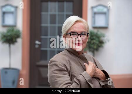 Köln, Deutschland. Juni 2021. Angelika MILSTER in einer Gastrolle bei UNTER UNS, die Saengerin und Schauspielerin als Gaststar in der Rolle von Hilde Müller. Auf den ersten Blick eine sehr charmante, gutherzige Oma, die gerne auf der Bank in der Sonne sitzt und Tauben füttert: Aber alles ist eine Fassade! In Wirklichkeit führt sie ein doppeltes kriminelles Leben. Porträt, Porträt, Porträt, Einzelbild beschnitten, Einzelbild, Einzelbild, Im Hintergrund der Wesen. UNTER UNS in den MMC Studios Köln, Fotosession am 24. Juni 2021 in Köln, Übertragung vom 22. September 2021 auf RTL, Quelle: dpa/Alamy Live News Stockfoto