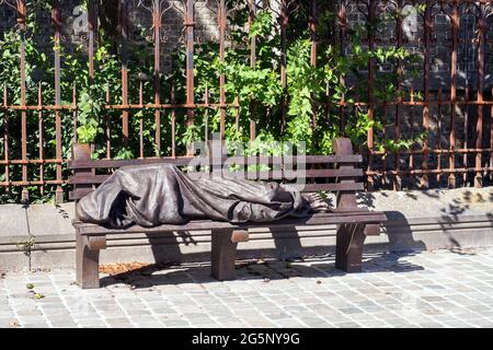 Skulptur eines obdachlosen Jesus, der auf einer Parkbank schläft Es ist eine Kopie eines Werkes in Toronto des kanadischen Bildhauers Timothy Schmalz - Bruges, Begium Stockfoto