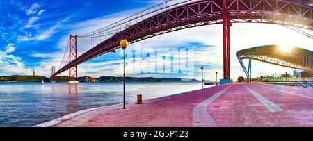 Panoramabild der Brücke 25 de Abril in der Stadt Lissabon über den Fluss Tajo. Lissabon Landschaft bei Sonnenuntergang Stockfoto