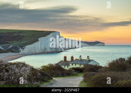 Seven Sisters und Beachy Head mit Küstenschutzhütten in Seaford Head bei Sonnenaufgang im Frühjahr, Seaford, East Sussex, England, Vereinigtes Königreich, Europa Stockfoto