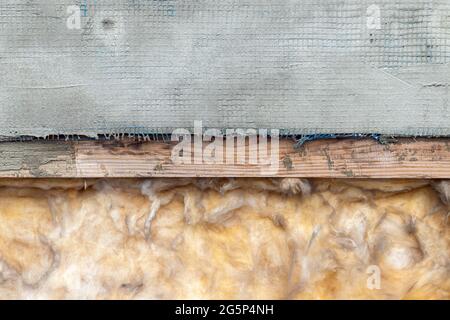 Dämmung der Decke, des Dachs oder der Wände. Fiberglas, Holz, zementierte Mesh-Hintergrundstruktur Stockfoto