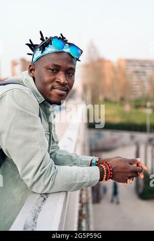 Junger und glücklicher afrikanischer Mann, der auf der Straße steht und die Kamera anschaut. Stockfoto