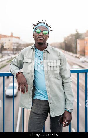 Ein cooler und selbstbewusster afrikanischer Mann, der eine Sonnenbrille trägt und die Kamera anschaut. Stockfoto