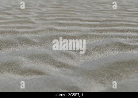 Wellen und Gezeiten im Sand am Strand Stockfoto