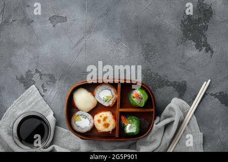 Selbstgemachte Sushi Bento Box mit Sushi Rolls Set, auf grauem Steingrund, Draufsicht flach liegend, mit Copyspace und Platz für Text Stockfoto