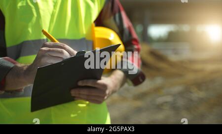 Baumeister mit Hut inspiziert Baustelle. Nahaufnahme. Stockfoto