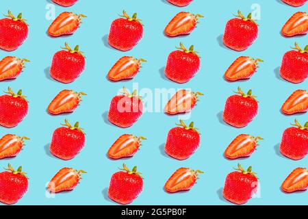 Erdbeere. Ein Muster aus Erdbeeren auf farbigem Hintergrund. Ganze und halbe Früchte schneiden, flach legen Stockfoto