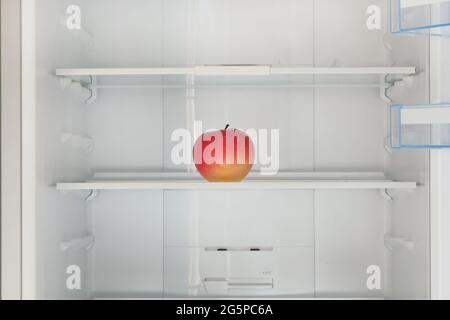 Roter reifer Apfel auf dem Regal im Kühlschrank. Gesundheit Hunger, Gewicht zu verlieren. Rohe Ernährung, hungernde Konzept. Stockfoto