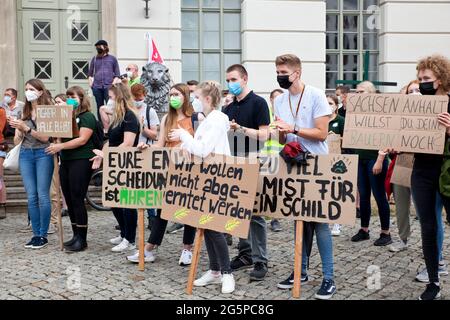 29. Juni 2021, Sachsen-Anhalt, Halle (Saale): Demonstranten sitzen mit ihren Plakaten vor der Martin-Luther-Universität. Bauern aus Sachsen-Anhalt und Studierende der Universität (MLU) demonstrieren gemeinsam gegen die Kürzungspläne der Universität, die auch das Departement für Agrarwissenschaft betreffen würden. Foto: Johannes Stein/dpa-Zentralbild/dpa Stockfoto