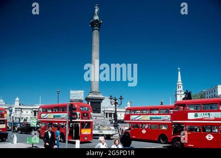 Rote Doppeldeckerbusse entlang des Trafalgar Square und der Nelson's Column, London, England, Großbritannien. Circa1980's Stockfoto