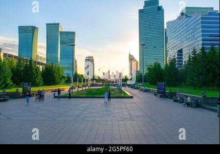 Nur-Sultan - Kasachstan: 10. Juni 2021: Zentrum von nur-Sultan mit Park, Einkaufszentrum Keruen und Wolkenkratzern auf dem Nurjol Boulevard, Menschen bei Sonnenuntergang Stockfoto