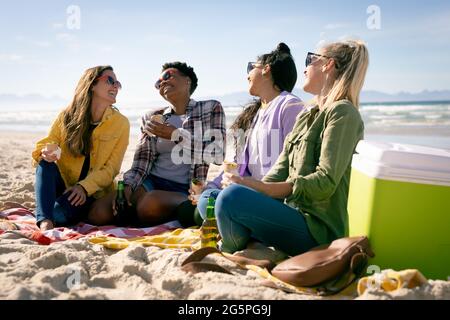 Fröhliche Gruppe verschiedener Freundinnen, die Spaß haben und am Strand lachen Stockfoto