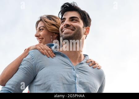 Ein paar junge Leute, die Spaß im Freien haben, umarmen sich zusammen. Stockfoto
