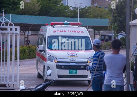 Phnom Penh, Kambodscha. 29. Juni 2021. Seit 4 Monaten kämpft Phnom Penh gegen einen COVID - 19-Anstieg. Ein Krankenwagen mit zwei EMTs in voller PSA verlässt eine Massenteststelle mit einem Coronavirus-positiven Patienten. Quelle: Kraig lieb / Alamy Live News Stockfoto