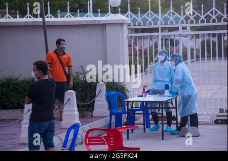 Phnom Penh, Kambodscha. 29. Juni 2021. Seit 4 Monaten kämpft Phnom Penh gegen einen COVID - 19-Anstieg. Zwei EMTs in voller PSA sprechen mit einem COVID-positiven Patienten, während sie sich sozial distanzieren, am Eingang zu einer Massenteststelle. Quelle: Kraig lieb / Alamy Live News Stockfoto