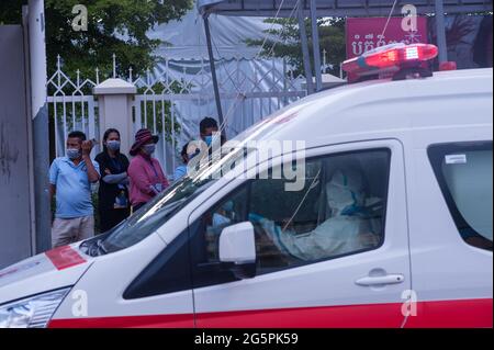 Phnom Penh, Kambodscha. 29. Juni 2021. Seit 4 Monaten kämpft Phnom Penh gegen einen COVID - 19-Anstieg. Ein EMT in voller PSA wartet in einem Krankenwagen an einem Massentestplatz, um eine Gruppe von Kambodschanern abzuholen, die alle positiv auf das Virus getestet haben. Kraig Lieb / Alamy Live News Stockfoto