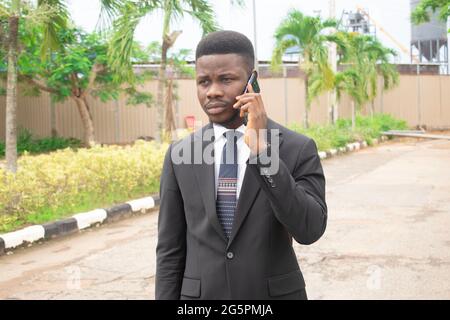 afrikanischer Mann im Anzug am Telefon Stockfoto