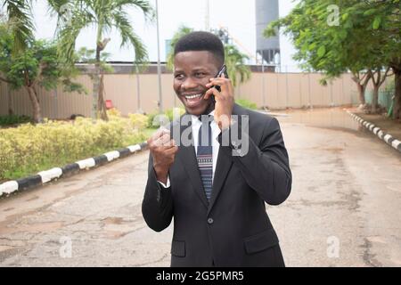 Bild eines hübschen afrikanischen Geschäftsmannes, der auf dem Handy spricht Stockfoto