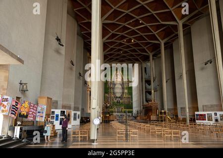 Das Innere der Coventry Cathedral, auch bekannt als St. Michaels, eine moderne Kathedrale, die 1956 gegründet wurde und bekannt ist für ihre atemberaubende modernistische Glasmalerei, ihre minimalistische Struktur und ihren großformatigen Wandteppich am 23. Juni 2021 in Coventry, Großbritannien. Die Cathedral Church of Saint Michael, allgemein bekannt als Coventry Cathedral, ist der Sitz des Bischofs von Coventry und der Diözese Coventry innerhalb der Church of England. Die heutige St. Michaels Kathedrale, die neben den Überresten der alten Kirche erbaut wurde, wurde von Basil Spence und Arup entworfen, von John Laing erbaut und ist ein denkmalgeschütztes Gebäude der I. Klasse. Stockfoto