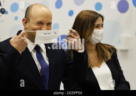 Holon, Israel. Juni 2021. Der israelische Premierminister Naftali Bennett lächelt, als er seine Schutzmaske während seines Besuchs bei einer Maccabi-Gesundheitsorganisation (HMO) anpasst, die am Dienstag, den 29. Juni 2021, in Holon bei Tel Aviv, Israel, Impfungen gegen die Coronavirus-Krankheit (COVID-19) anbietet. Poolfoto von Amir Cohen/UPI Credit: UPI/Alamy Live News Stockfoto