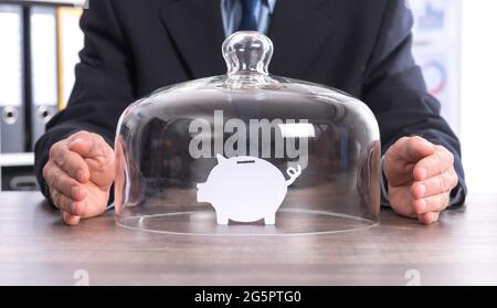 Konzept des Sparschutzes mit Papier Sparschwein unter einer Glaskuppel Stockfoto