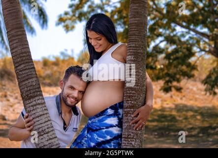 Foto eines jungen Paares. Der Kopf des Mannes ruht auf dem Bauch der Schwangeren Stockfoto