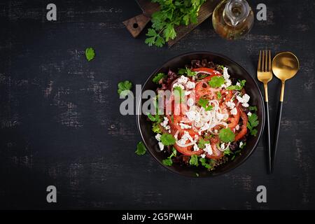 Gemüsesalat mit Tomaten, frischem Salat, Weichkäse und Zwiebeln. Gesunde Ernährung. Draufsicht, oben Stockfoto