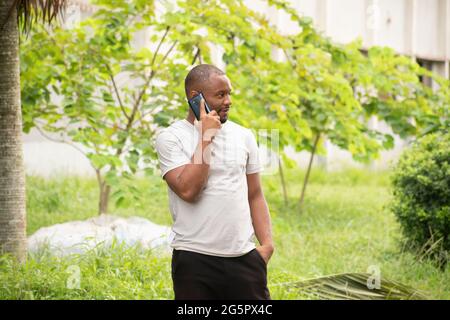 Ein junger Mann, der sich am Telefon unterhielt Stockfoto