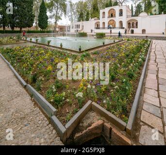 Mahan, Iran - 04.09.2019: Weitwinkelaufnahme eines Wasserbrunnens vor dem Hauptgebäude im historischen Garten Shahzadeh Mahan. Schöner persischer Ga Stockfoto