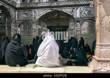 Qom, Iran - 04.20.2019: Islamische Frauen in traditionellen Kleidern treffen sich vor dem Eingang zum Fatima Masumeh-Schrein. Hazrat Masumeh Holly Shrine Stockfoto