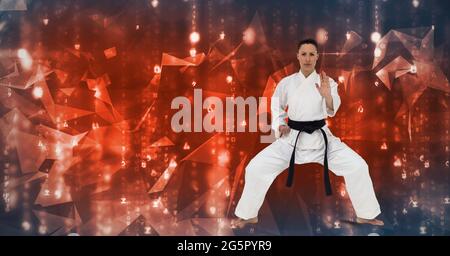 Kaukasische Kampfkünstlerin mit schwarzem Gürtel gegen Plexusnetze auf blauem Hintergrund Stockfoto