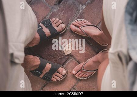 Draufsicht auf Männer und Frauen, die Sandalen und Flip-Flops tragen und einander gegenüberstehen. Sommer, Abenteuer, Rucksackreisen, Reisekonzept. Stockfoto