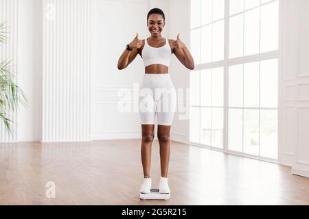 Nahaufnahme einer Afrikanerin, die auf einer Waage steht. Schlankheitskonzept Stockfoto