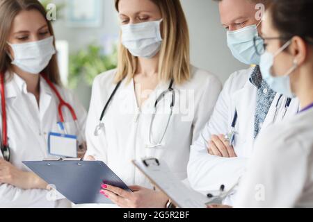 Ärzteteam in einer medizinischen Schutzmaske, die die Ergebnisse der medizinischen Untersuchung untersucht Stockfoto