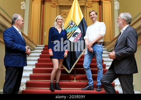 29. Juni 2021, Sachsen-Anhalt, Magdeburg: Reiner Haseloff (l-r, CDU), Ministerpräsident in Sachsen-Anhalt, steht neben den Sachsen-anhaltinischen Einheitsbotschaftern, der Kreativpilotin Kristin Knufmann und dem Filmproduzenten Falk Schuster sowie dem Land- und Kulturminister Rainer Robra vor der Landesflagge im Bundeskanzleramt. Sachsen-Anhalt, Gastgeber der diesjährigen zentralen Feierlichkeiten, stellt sich anlässlich des Tages der Deutschen Einheit eine Innovation vor. Zum ersten Mal hat jeder Bundesstaat zwei Botschafter der Einheit ernannt, um seinen Staat zu repräsentieren und ihm ein Gesicht zu geben. Foto: Stockfoto