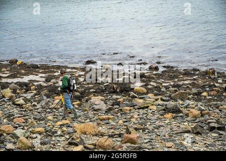 Mann mit einem Metalldetektor fegte über den Strand. Konzeptfoto der Suche oder der Suche nach Geld, Gold, Job, Metalle, Schatz, suchen, Jagen. Stockfoto