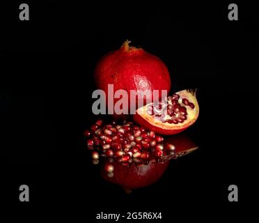 Saftig roter Granatapfel auf dunklem Grund Stockfoto
