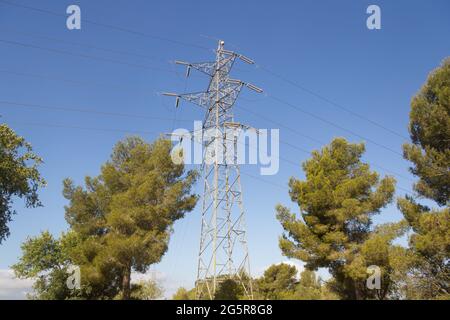 Ein elektrischer Turm in den Bergen, der das bergige Gelände überwindet, um Strom in die Industrie und in unsere Häuser zu bringen. Grüne Energie Stockfoto