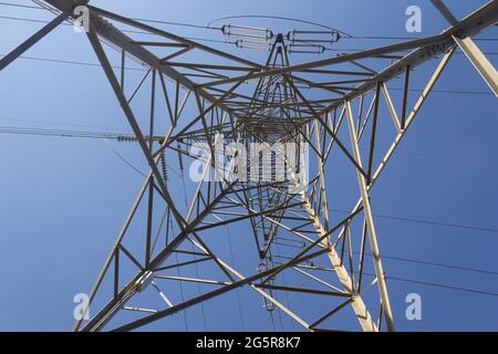 Ein elektrischer Turm in den Bergen, der das bergige Gelände überwindet, um Strom in die Industrie und in unsere Häuser zu bringen. Grüne Energie Stockfoto