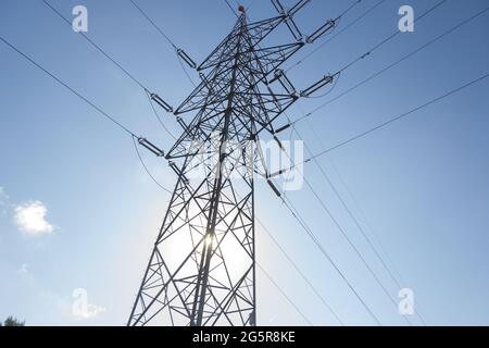 Ein elektrischer Turm in den Bergen, der das bergige Gelände überwindet, um Strom in die Industrie und in unsere Häuser zu bringen. Grüne Energie Stockfoto